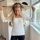 white scoopneck sweater with scalloped detail and buttons on sleeves
